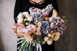Woman holding large bouquet of pastel flowers