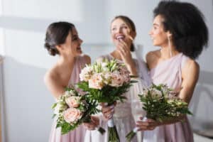 Three women with floral bouquets at wedding