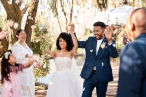 Bride and groom with arms up after ceremony