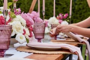 Hands setting table at outdoor wedding